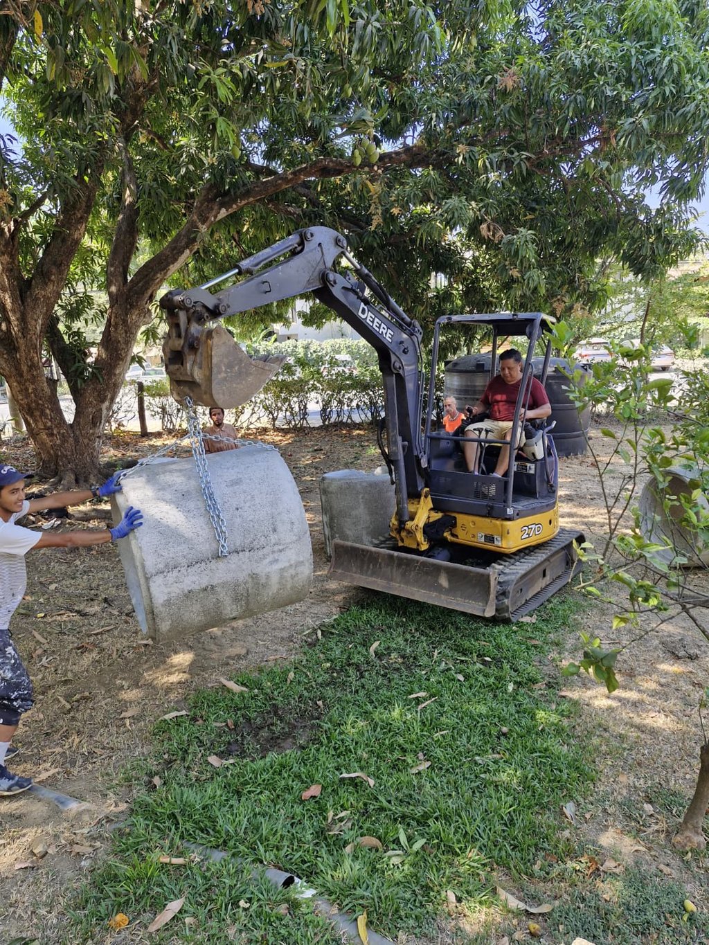 Mini excavator moving concrete septic pipes