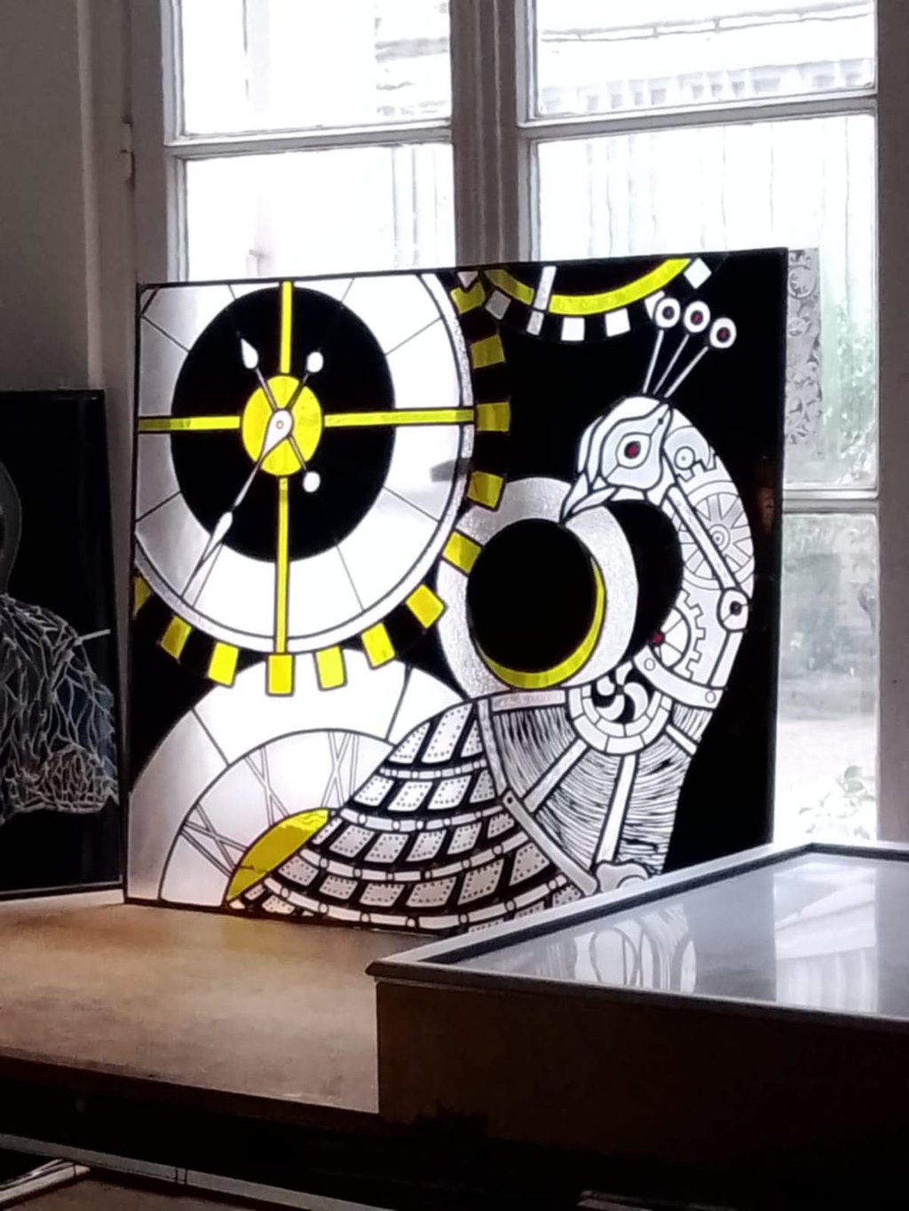 Panneau de vitrail contemporain à la lumière naturelle, jeu de transparence et contrastes jaune et noir.