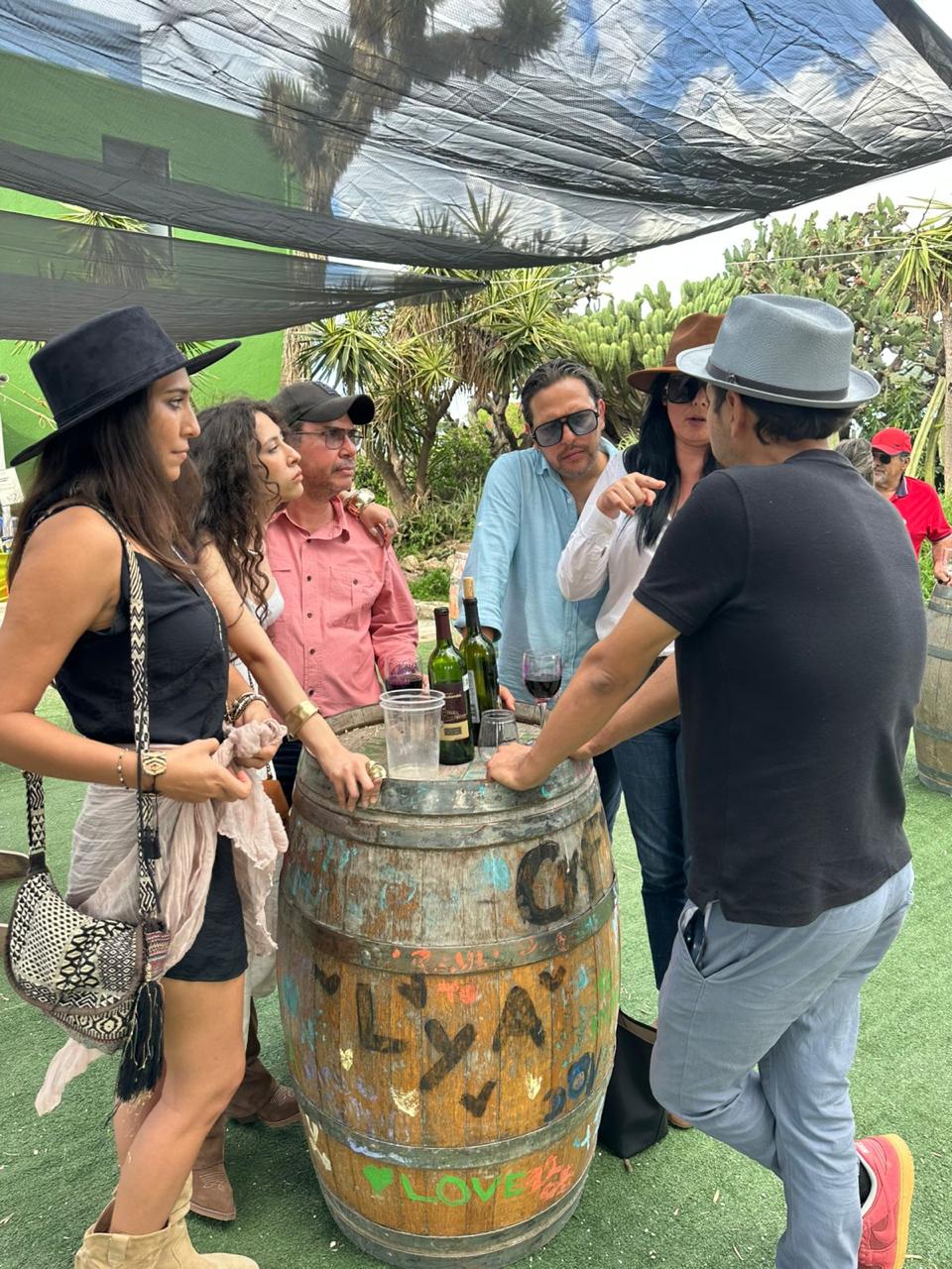 Grupo de amigos conversando junto a barril en viñedo de Querétaro
