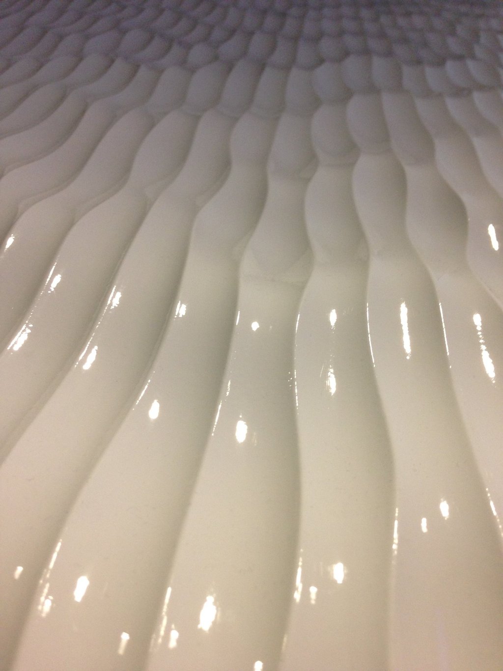 Heavy textured plastic surface with multiple paralel rounded bulging masses. 