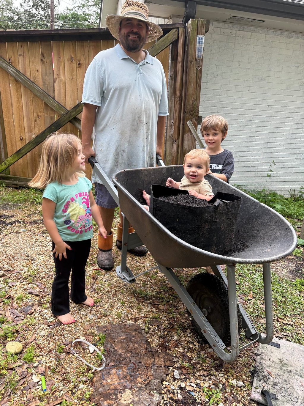 a man and three children in a wheelbarrow