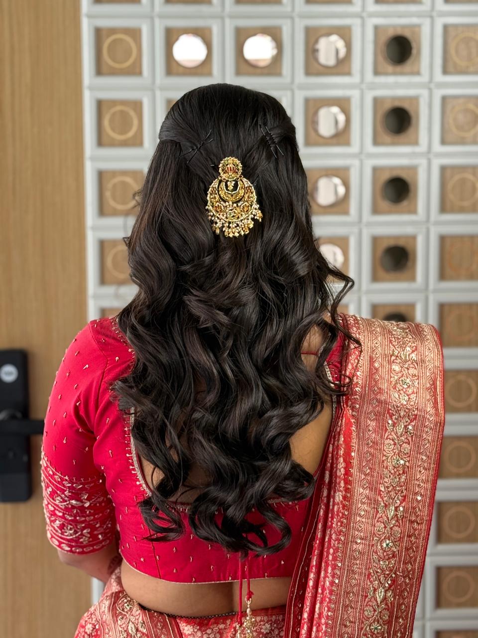  Elegant bridal hairstyle with a traditional gold hair accessory and soft curls for a Gujarati bride