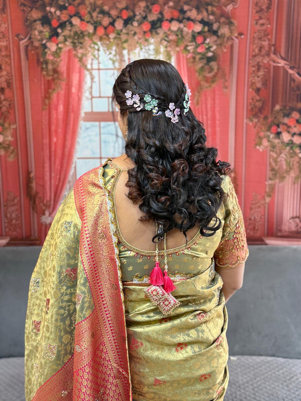 A beautiful open variation bridal hairstyle with a braided crown and purple-green floral accessories
