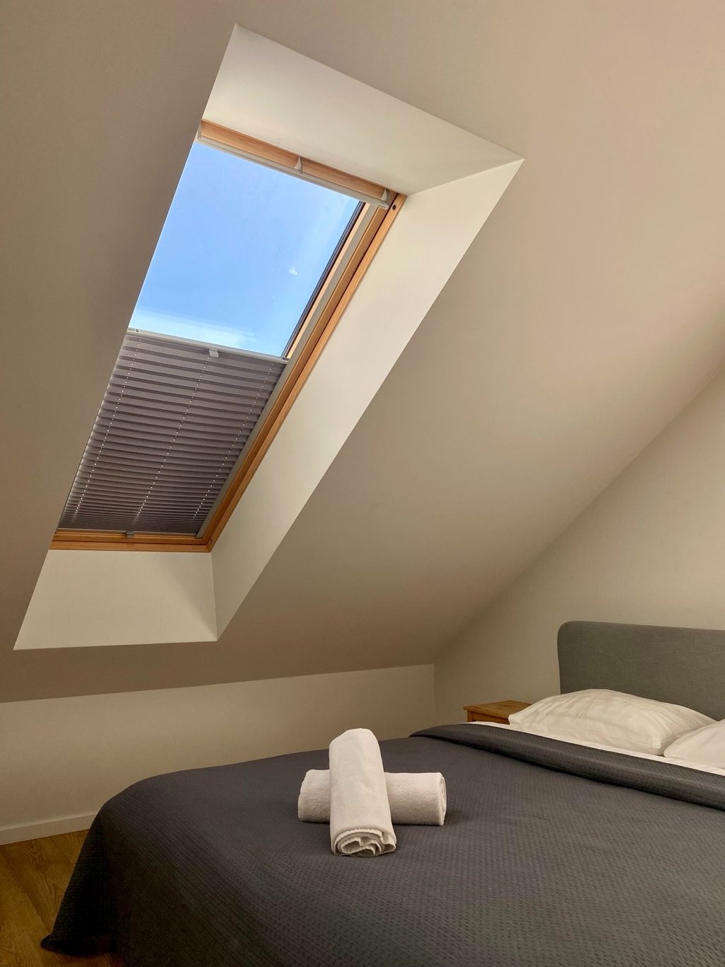 paveikslėlyje matyti plisuotos žaliuzės sumontuotos ant medžio spalvos stoglangio