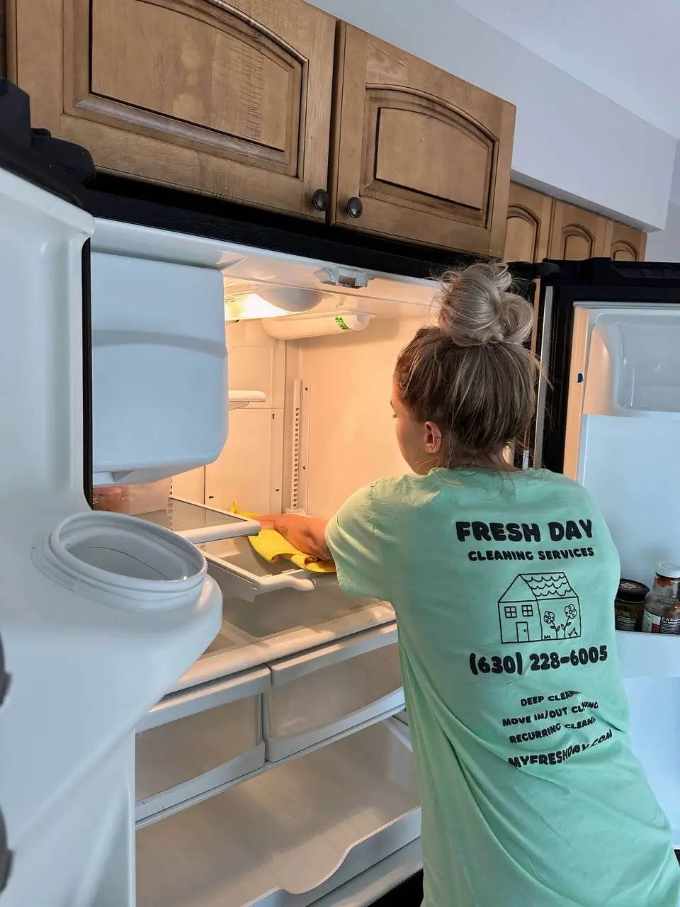 A professional cleaner thoroughly cleans inside of fridge
