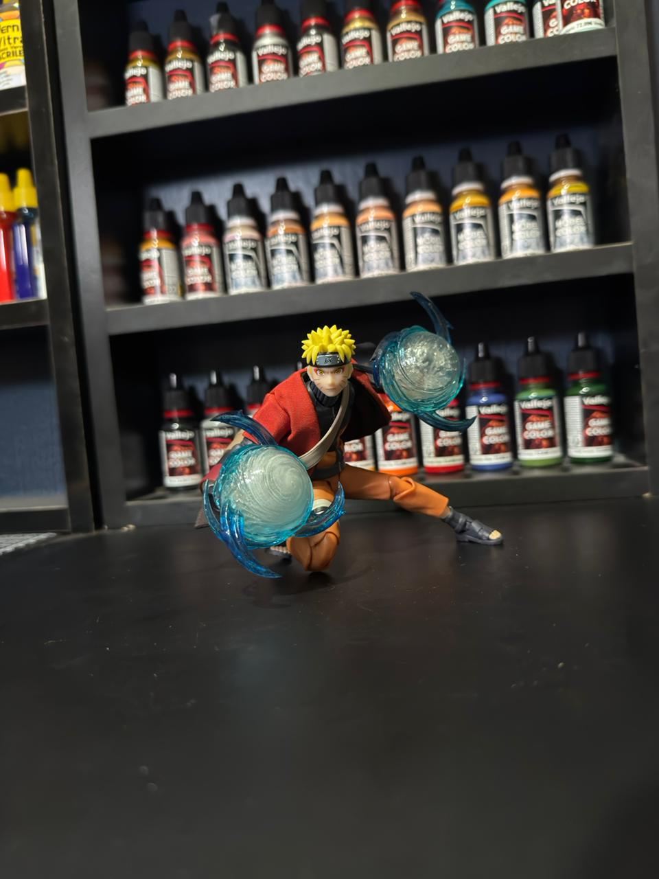 Naruto Uzumaki Sage Mode action figure posing with Rasengan effects in front of Vallejo paint bottles.