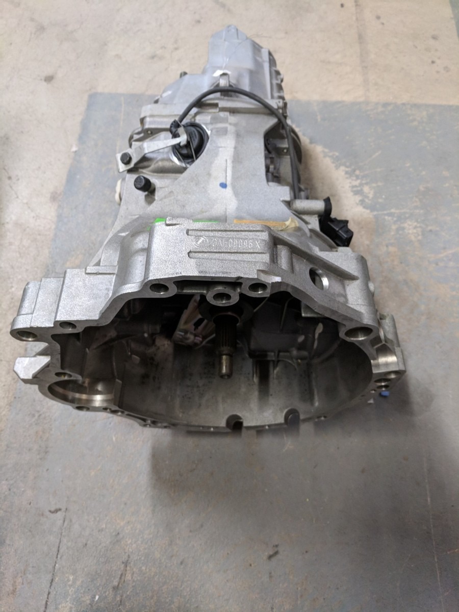 Used manual car transmission assembly for vehicle repair and replacement parts.