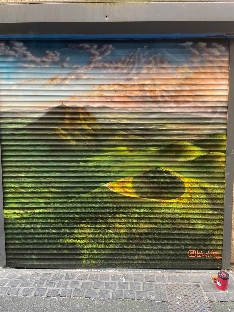 un rideau de fer avec un graffiti que représente la chaine des puys en Auvergne