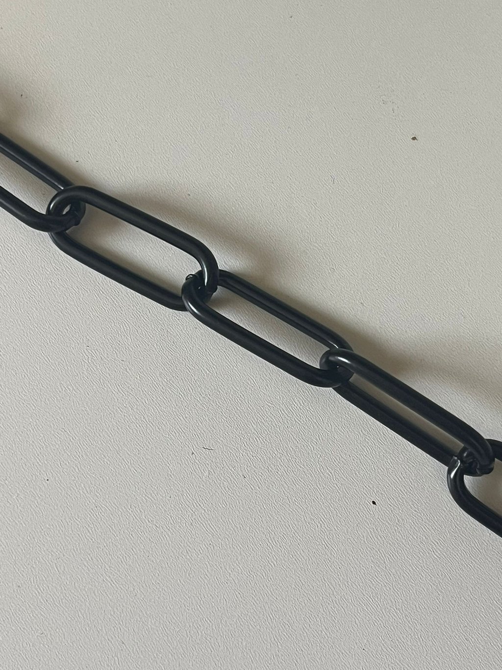 Runder Kreis mit einem Farbmuster mittig eine Kette in Schwarz, Hundekette, Pulverbeschichtet