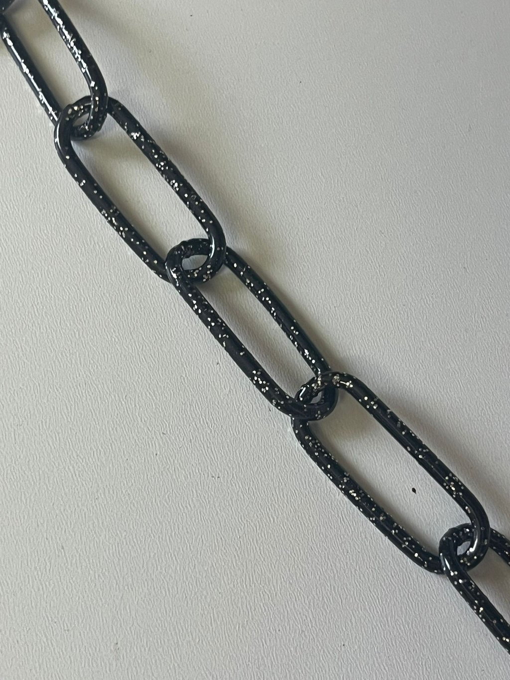 Runder Kreis mit einem Farbmuster mittig eine Kette in Schwarz Glitzer,Hundekette, Pulverbeschichtet