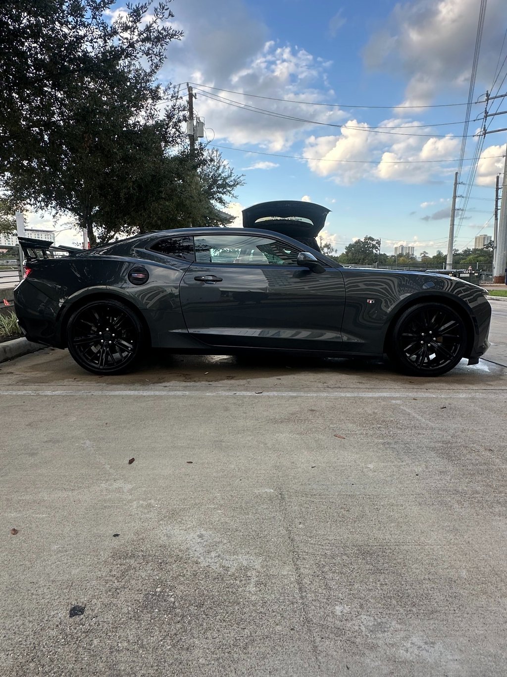 Side profile of a dark gray Chevrolet Camaro sports car after a hand wash and detail