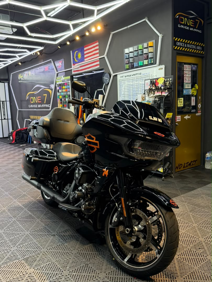 Harley-Davidson touring motorcycle with black and orange custom wrap