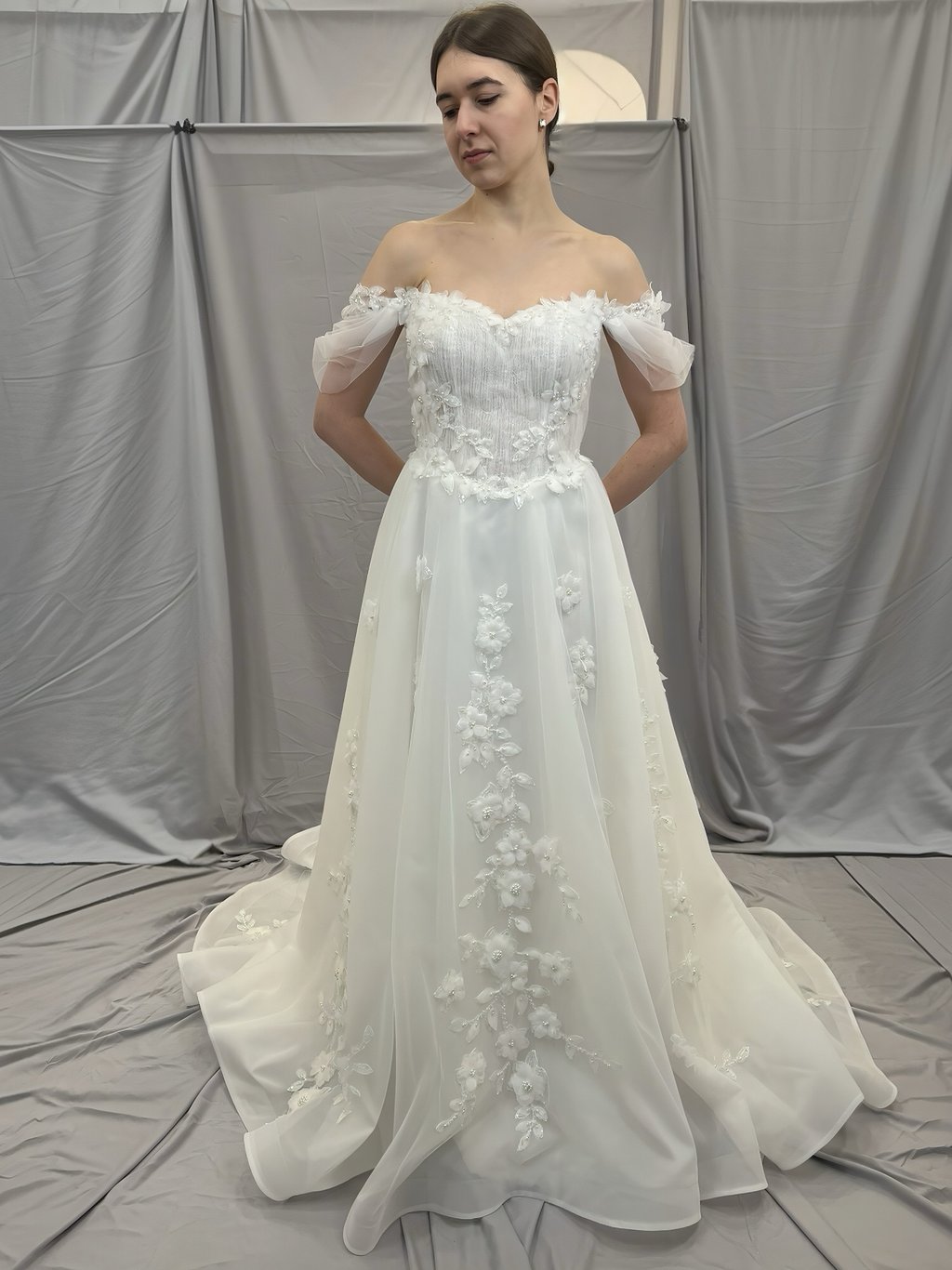 a woman in a wedding dress standing in front of a white backdrop