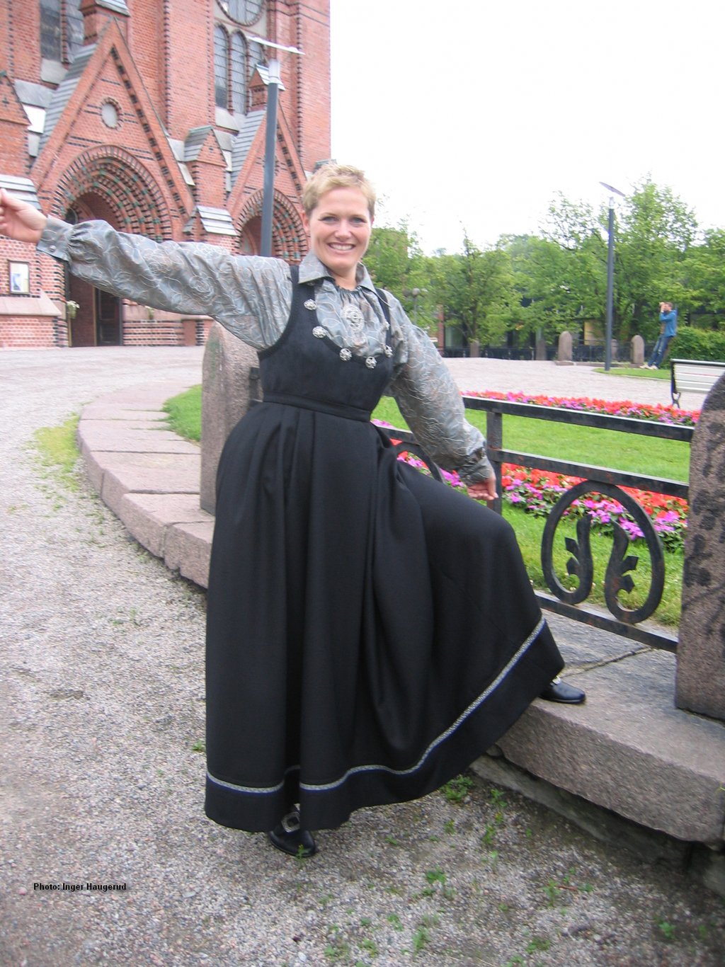 A woman in a black dress standing outside a church