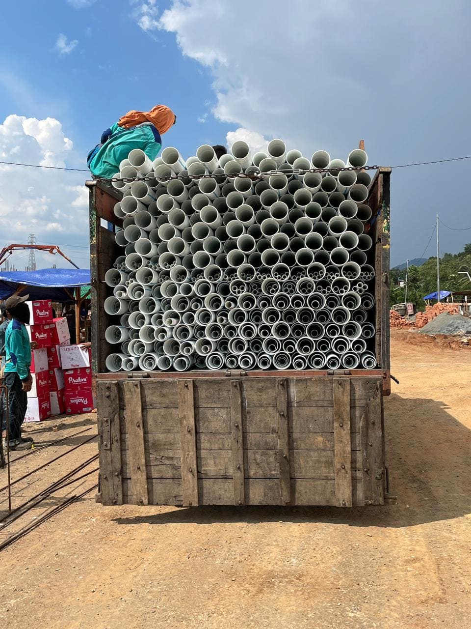 a truck with a man on the back of it pipa pvc pralon diatas truk dengan orang