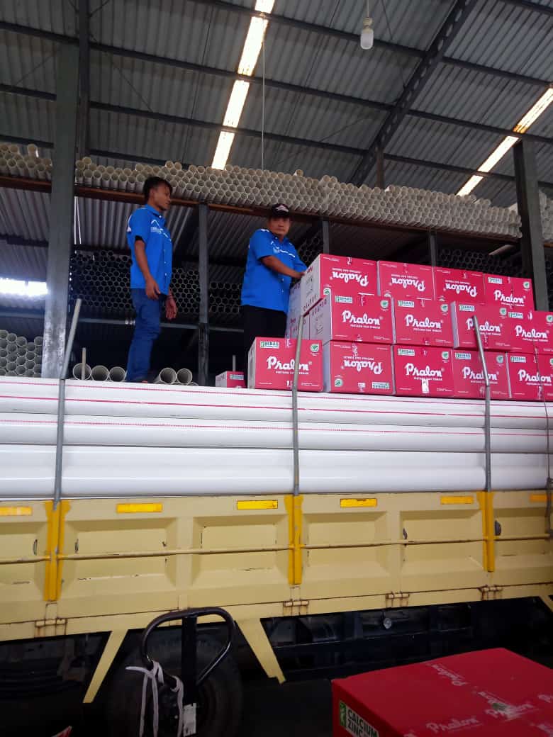 two men standing on a truck with boxes fittings pralon knee pipa pvc