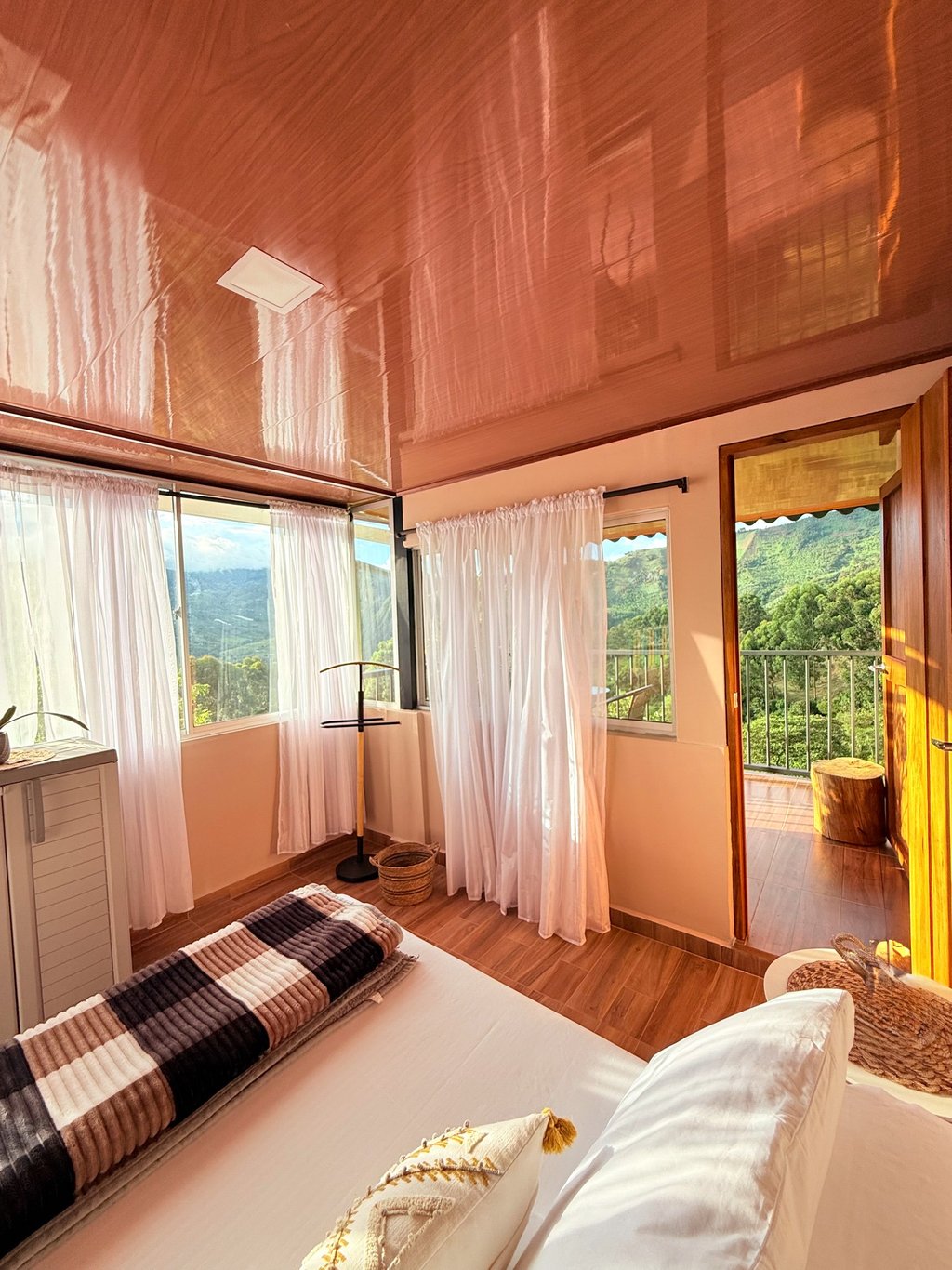 Habitación con cama doble, grandes ventanas con balcón