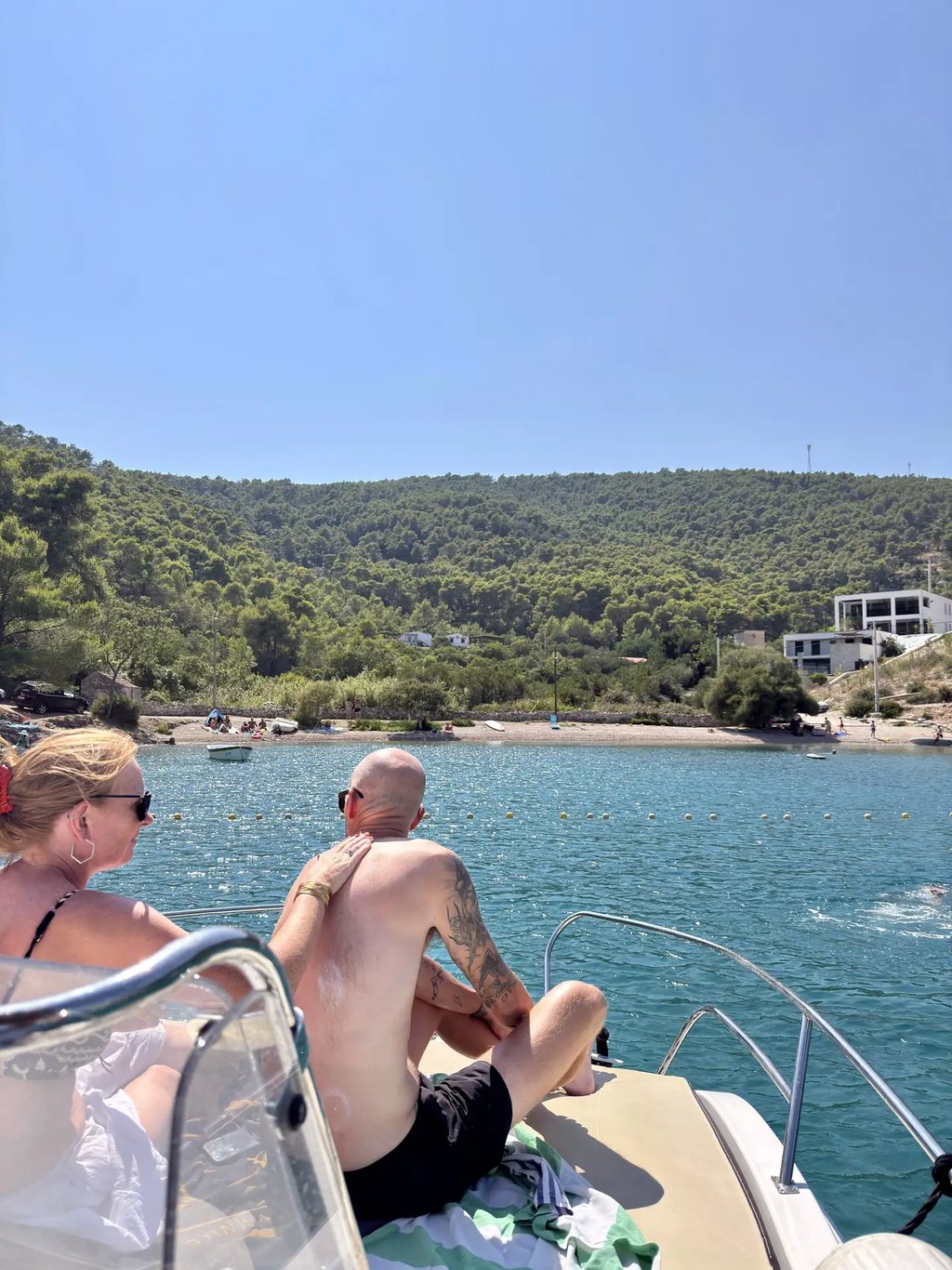 Couple applying sun protection on a boat at Krusica Bay on Solta during a private boat tour from Split