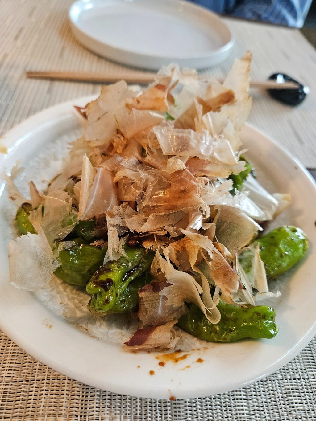 Blistered shishito peppers finished with dancing bonito flakes at Zōtō Sushi in Sarasota, Florida