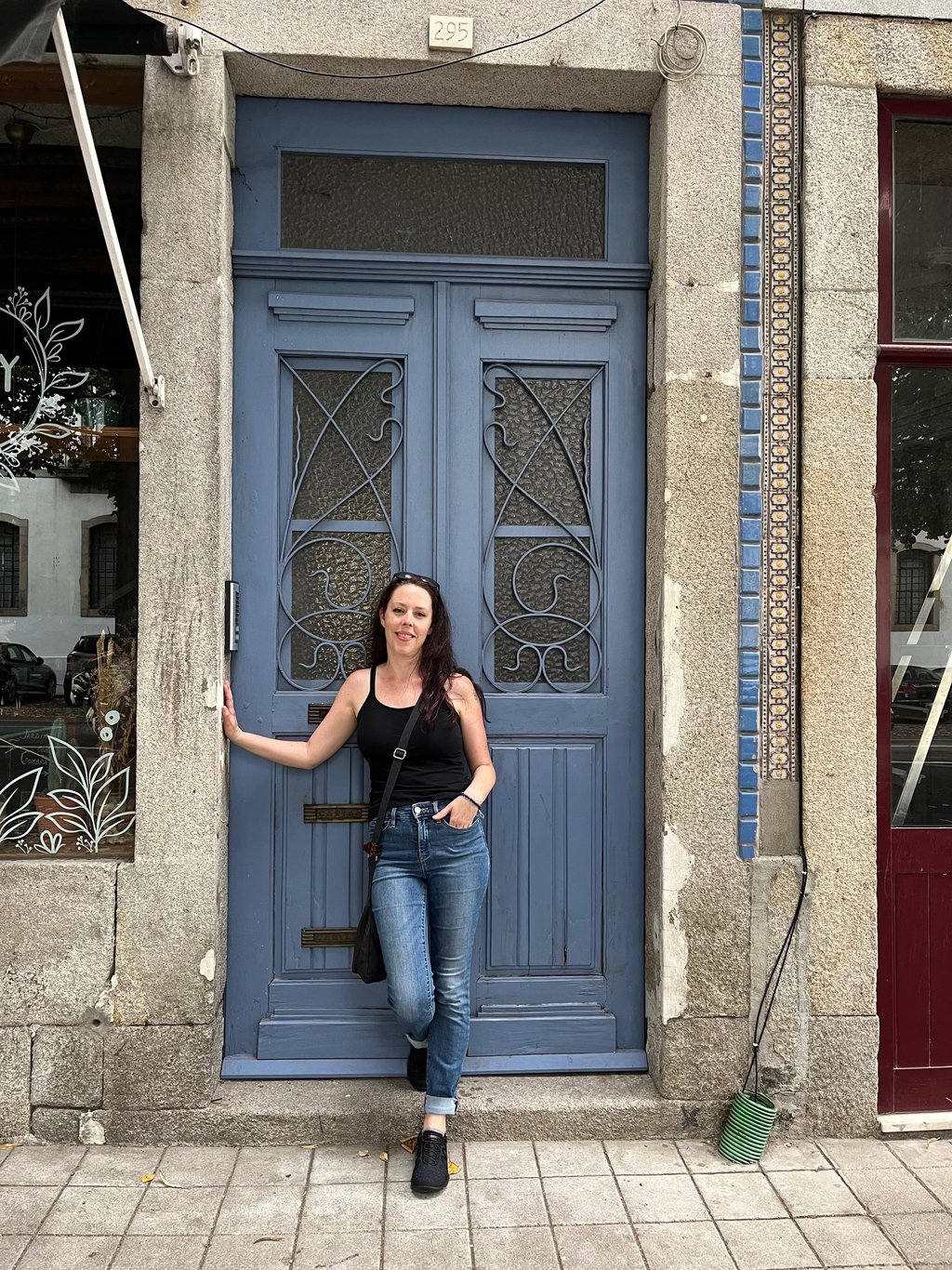 a woman standing in front of a blue door