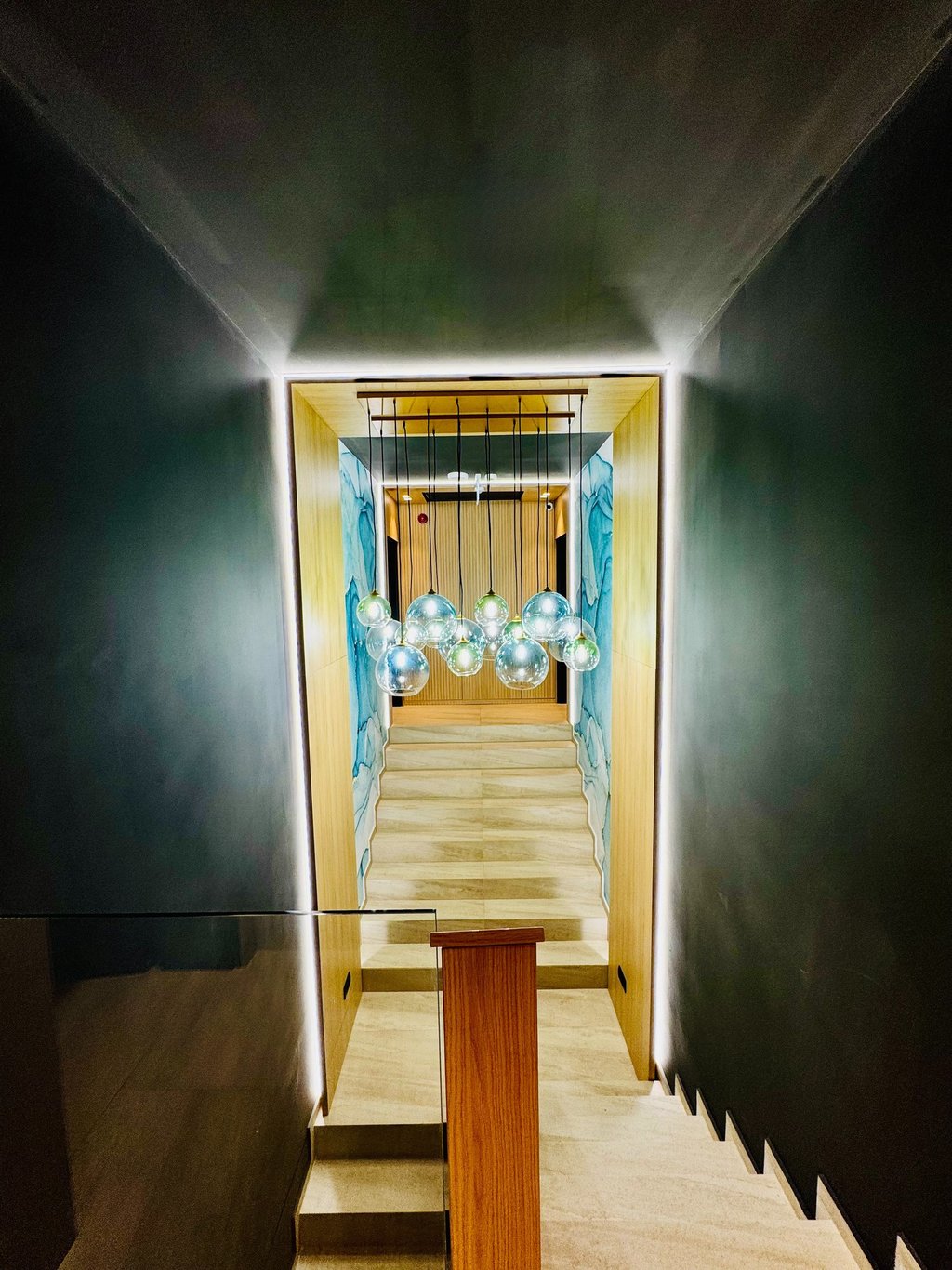 Holul principal elegant al Pensiunii MAPAMONT din Văliug, luminat de un candelabru masiv.