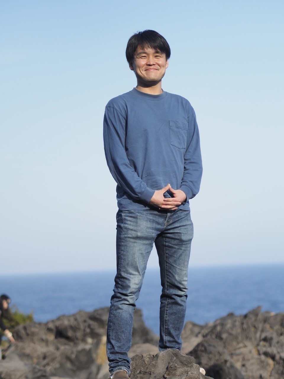 a man standing on a rock with his hands on his hips