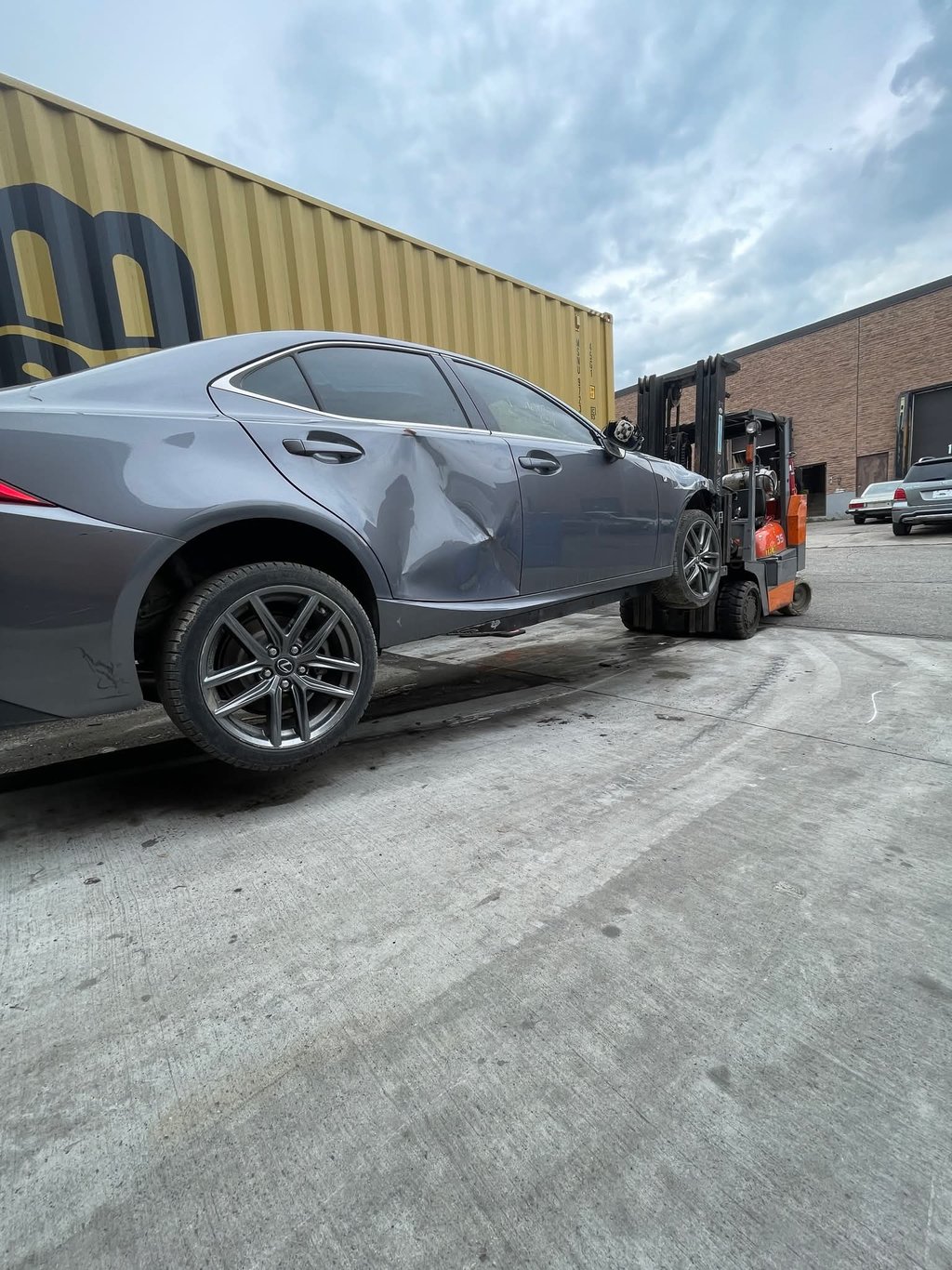 fork lift with fork extensions in use lifting a car