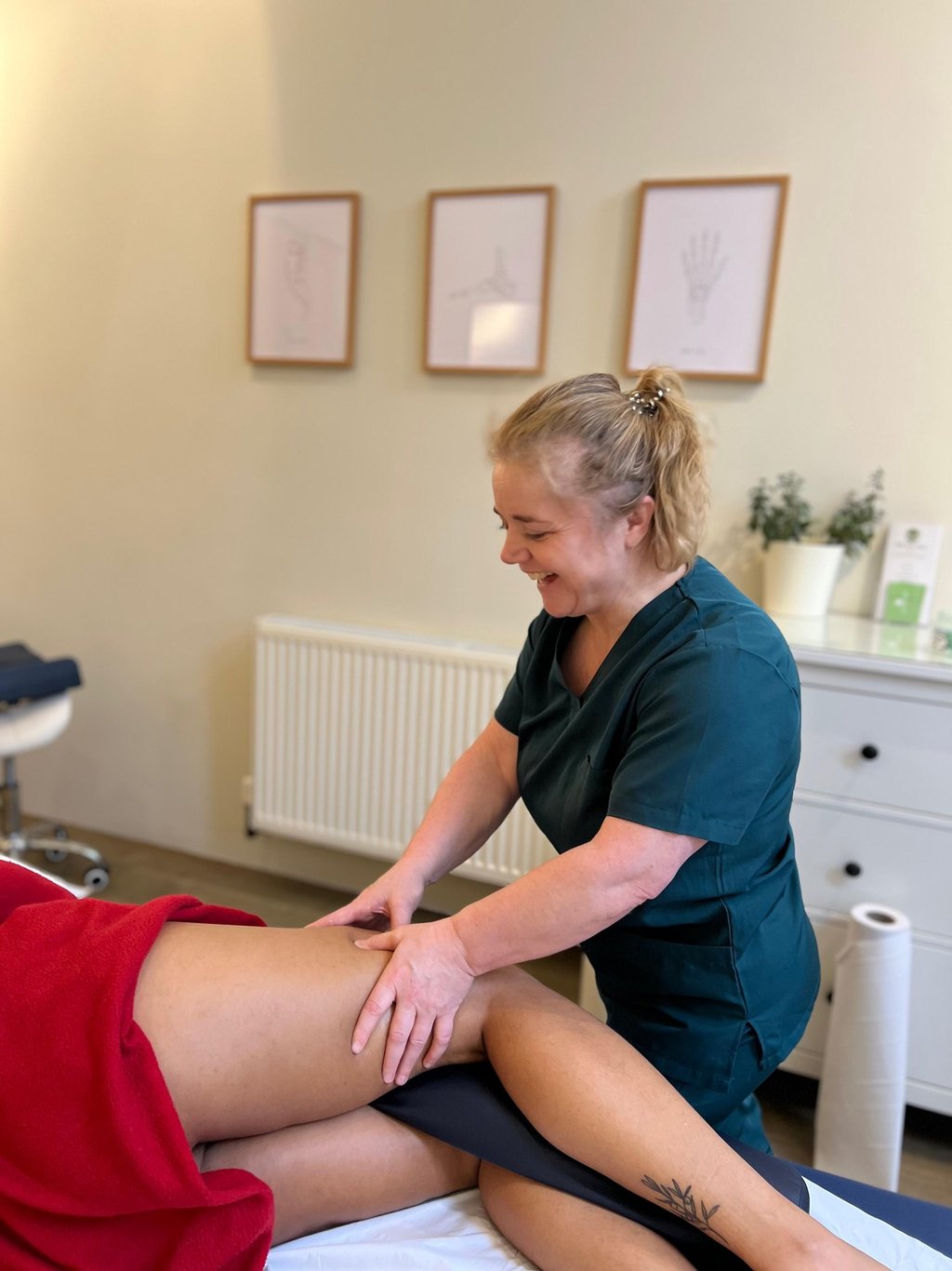 female massage therapist delivering sports massage to patient in clinic