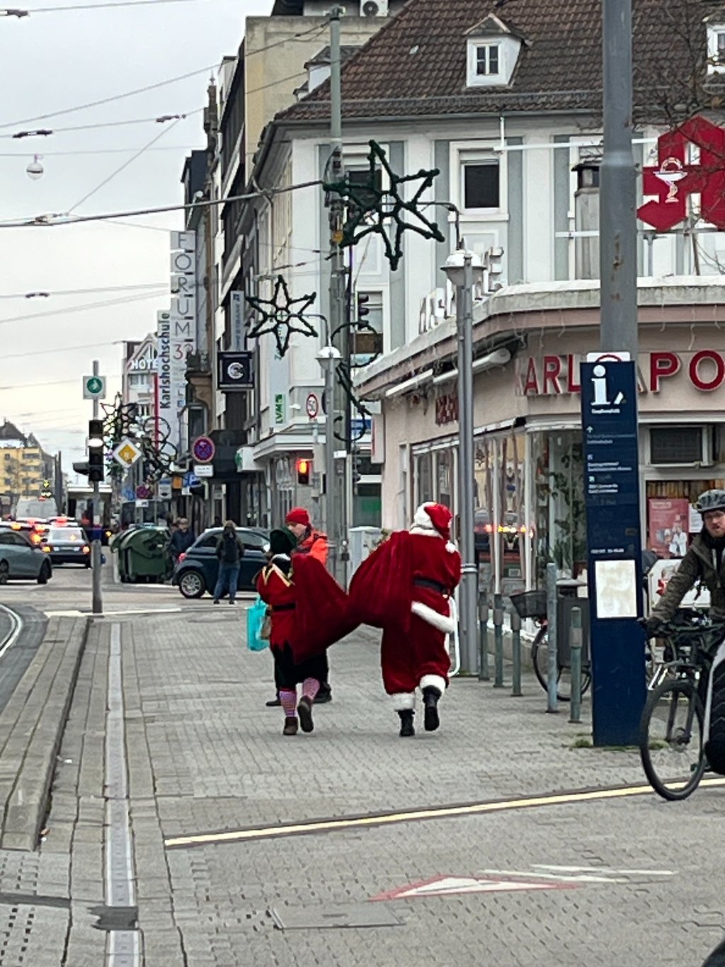 Santa and his elf walking a street in Karlsruhe