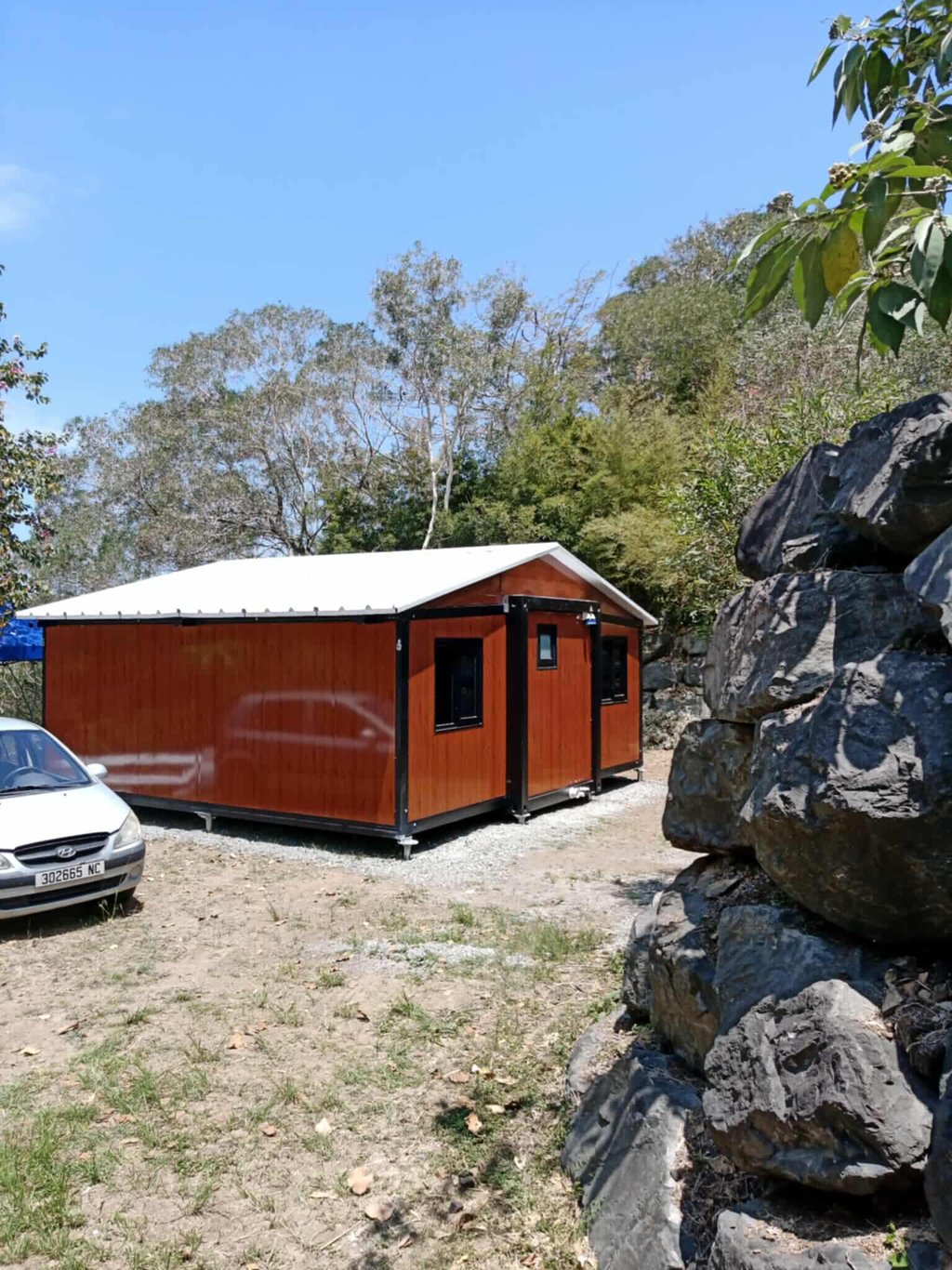 Chalet modulaire avec toit blanc sur un terrain sec et difficile.