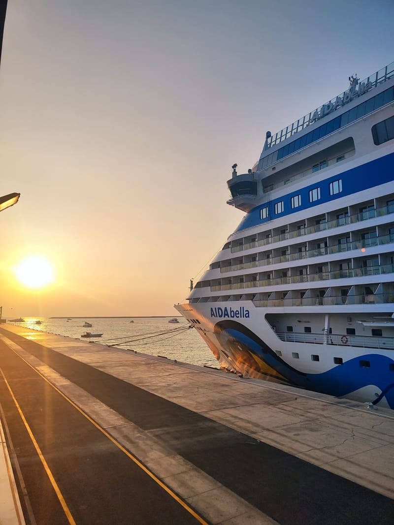 Das Kreuzfahrtschiff AIDAbella liegt während eines goldenen Sonnenuntergangs über dem Ozean