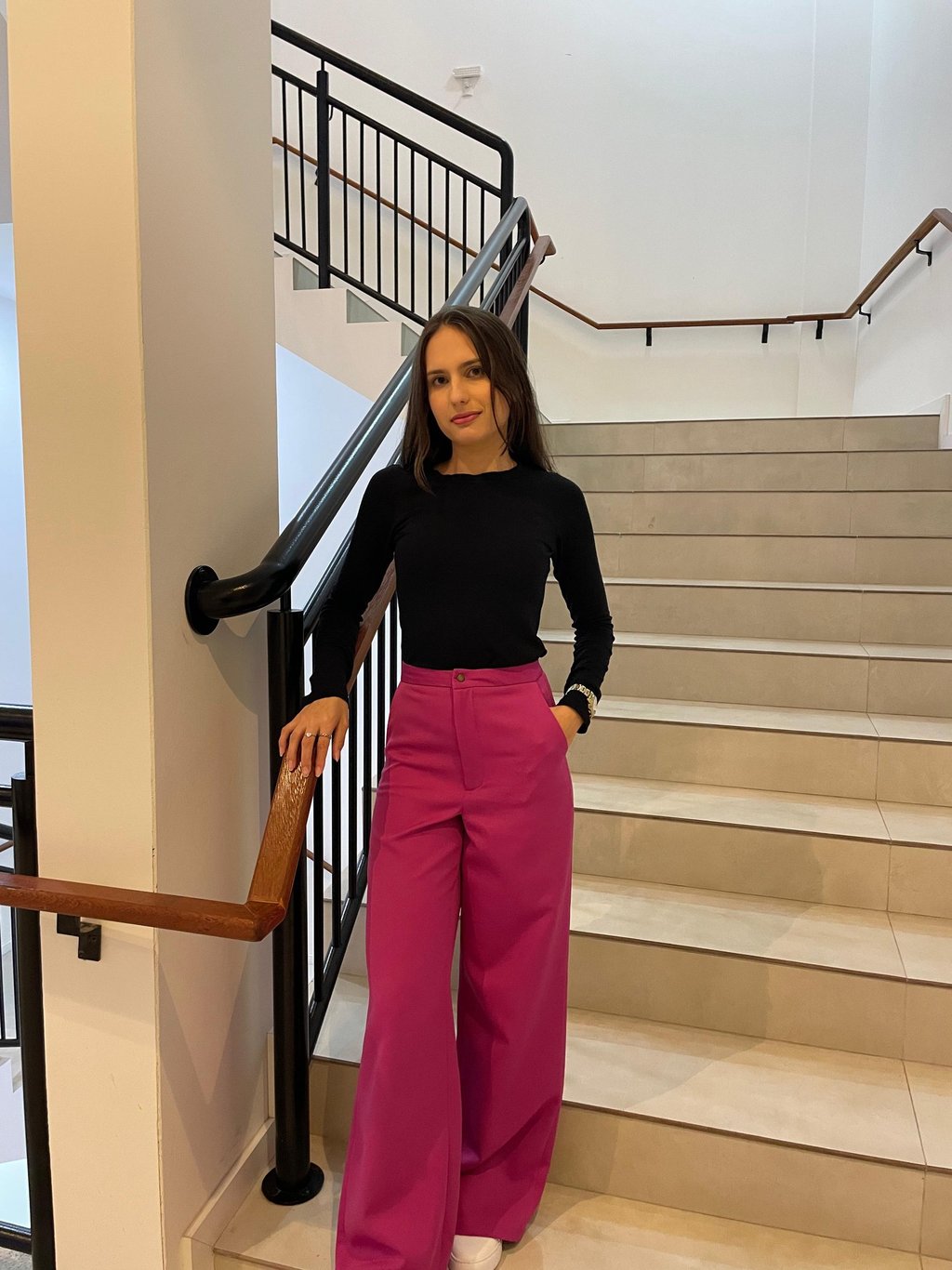 Mulher usando uma calça pantalona  rosa e blusa preta