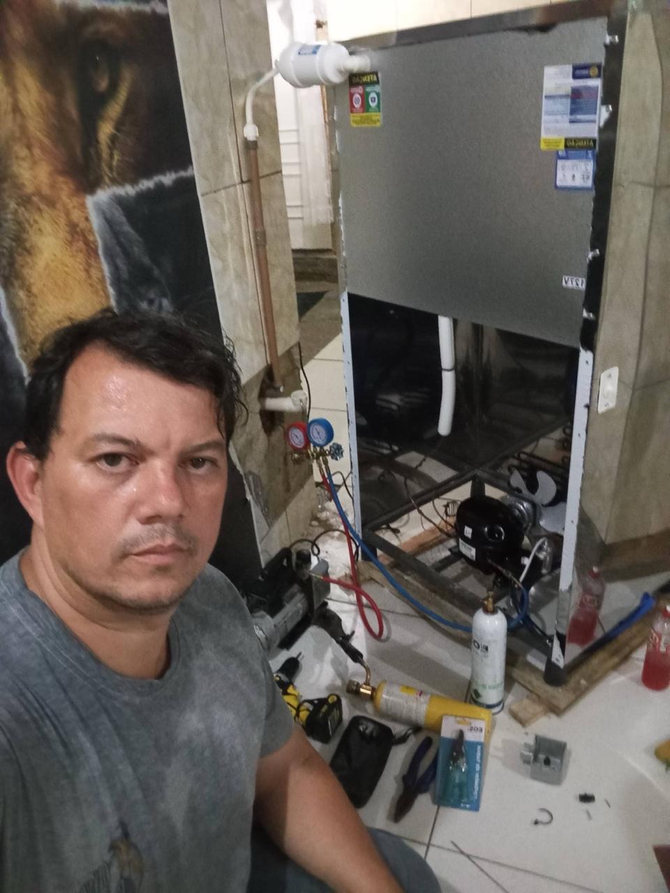 Técnico consertando geladeira