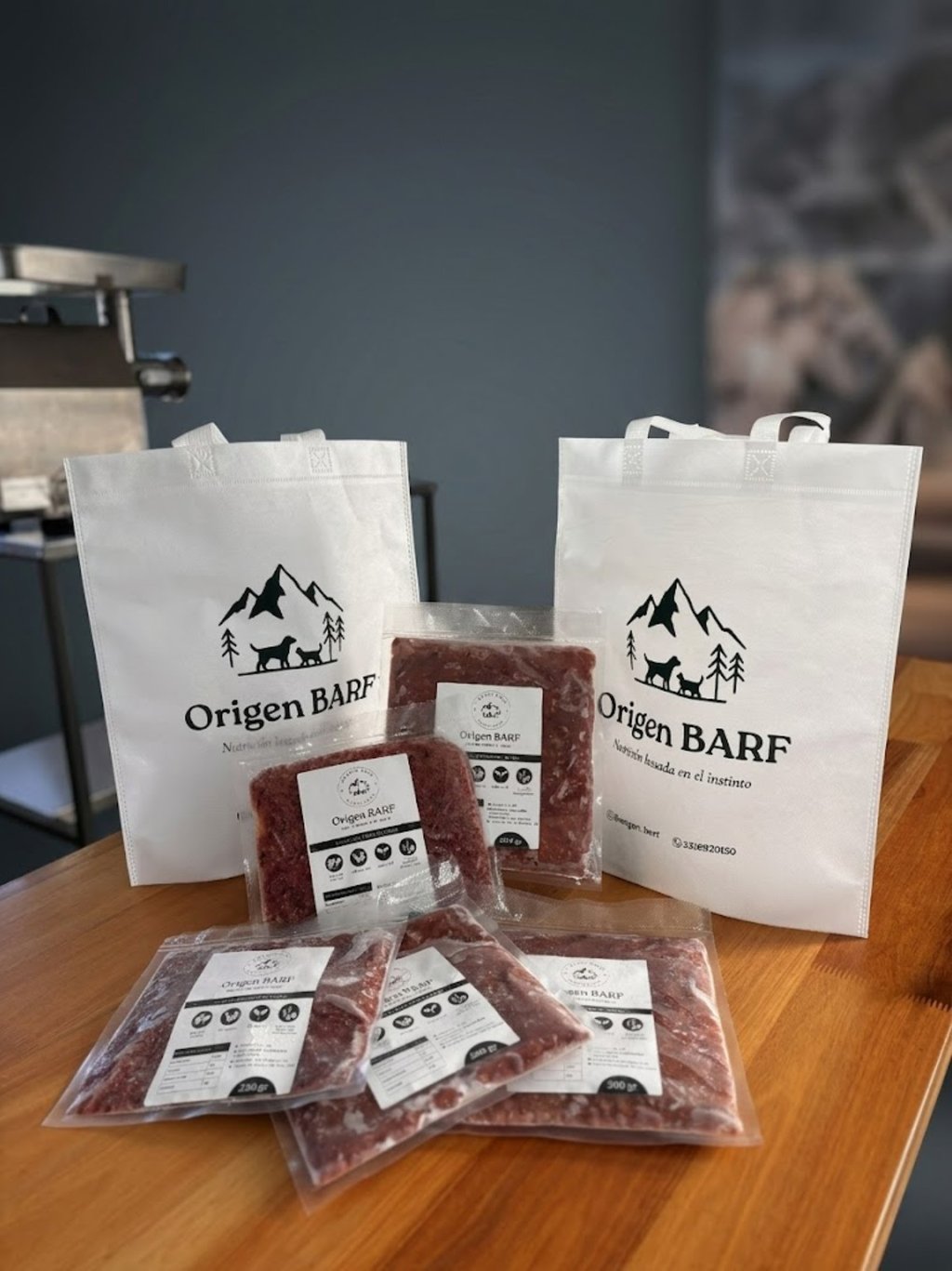 Viandas con alimento barf listas para servir junto a las bolsas de la marca origen barf