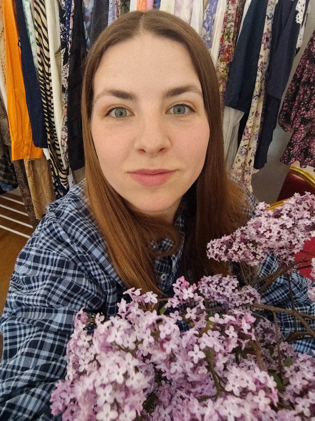kobieta z kwiatami bzu na tle ubrań