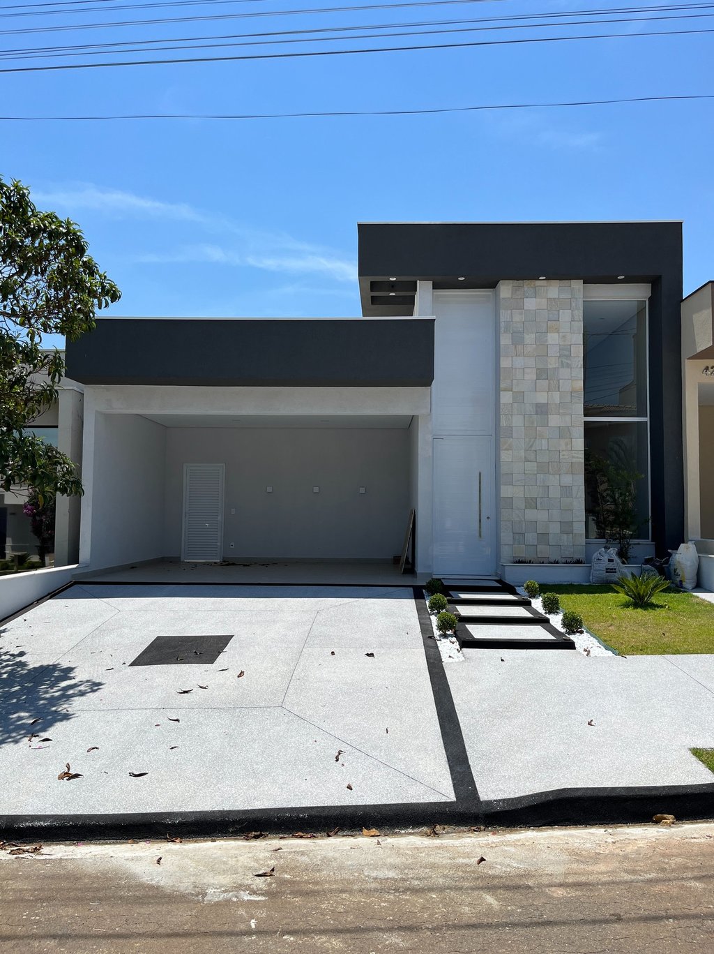 Fachada de sobrado moderno com garagem frontal e projetos estruturais integrados.
