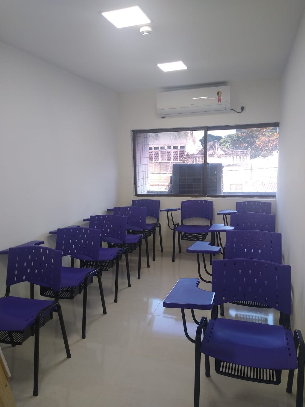 Sala de aula climatizada com 10 carteiras, datashow, notebook, quadro branco para cursos.
