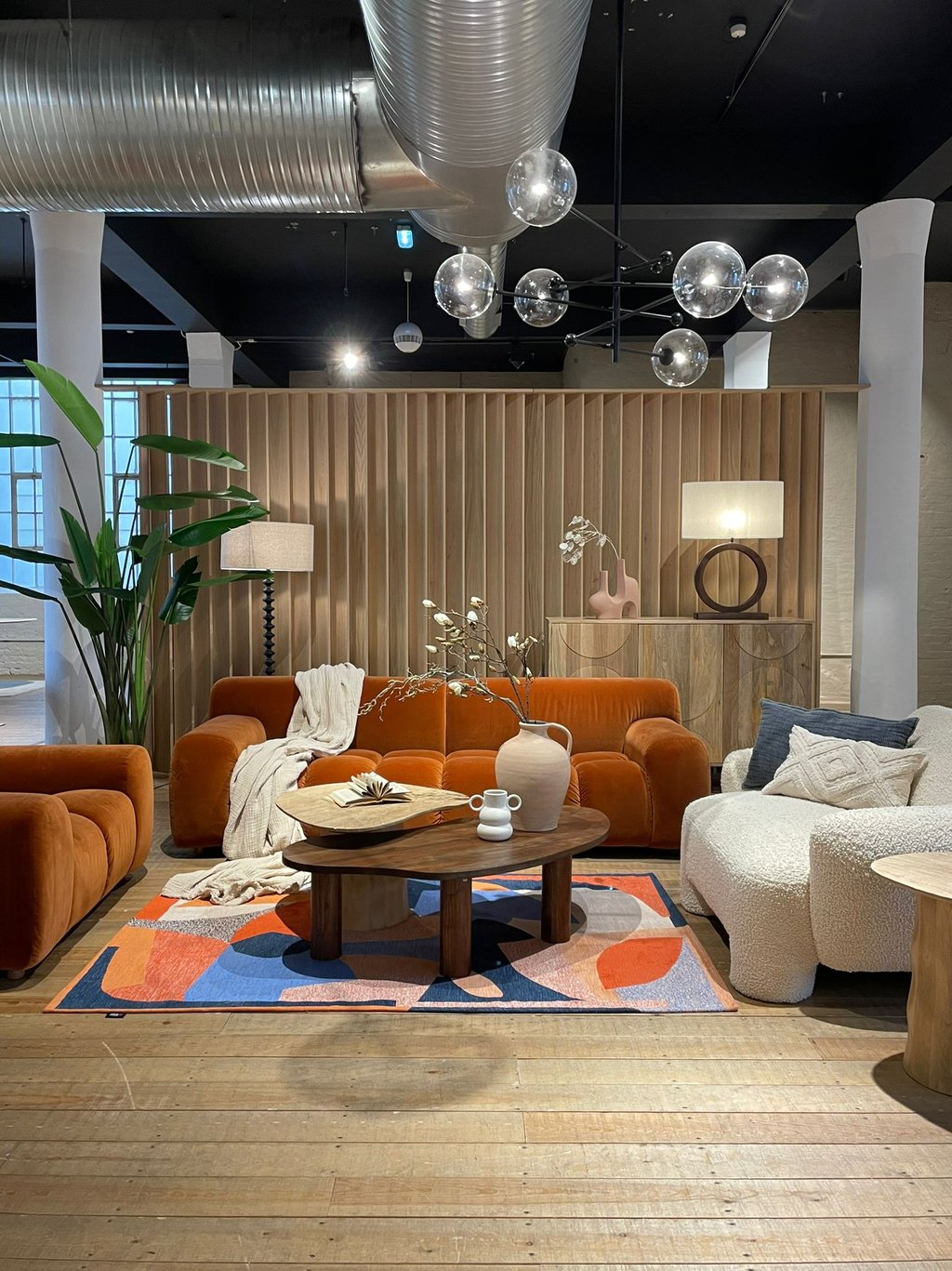 a living room with a sofa a armchair and a table and a console and accessories