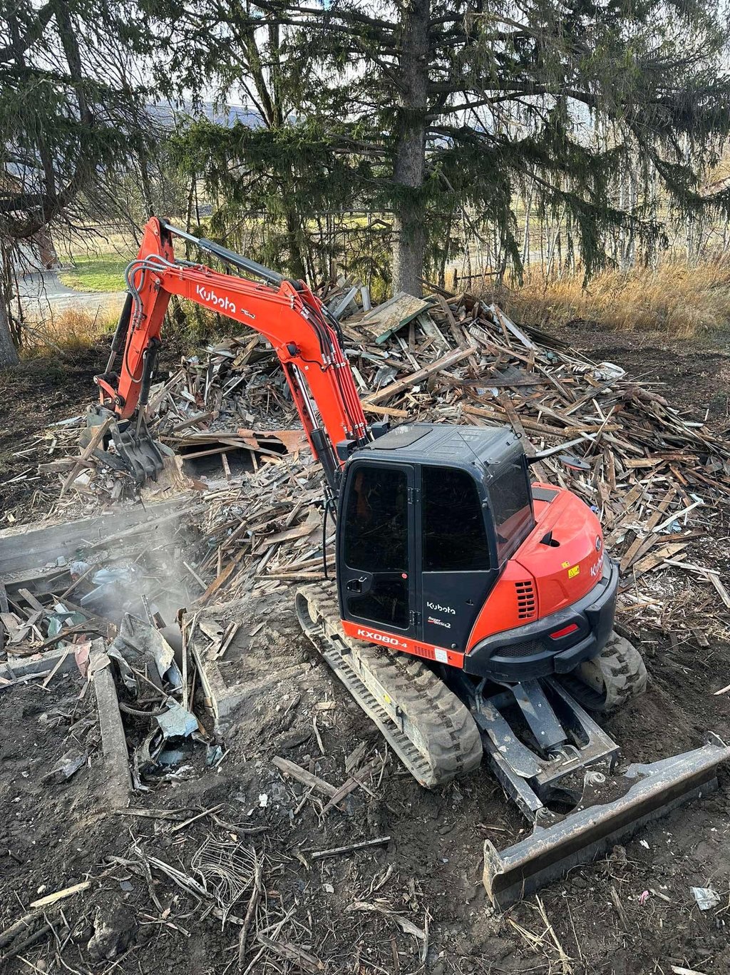 Kubota excavator demoing a residential structure