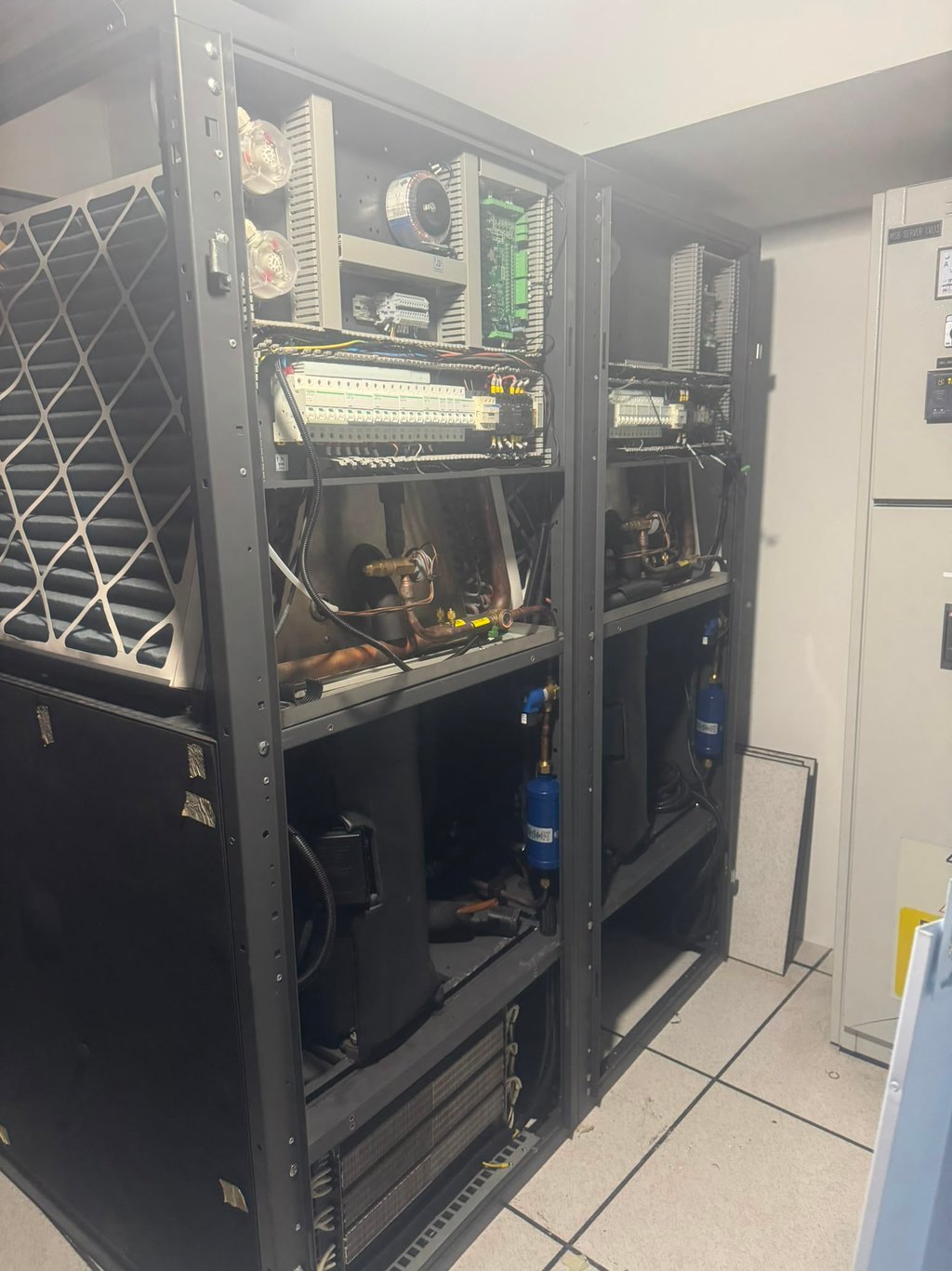 Industrial HVAC control panel and electrical cooling units inside a server room data center.