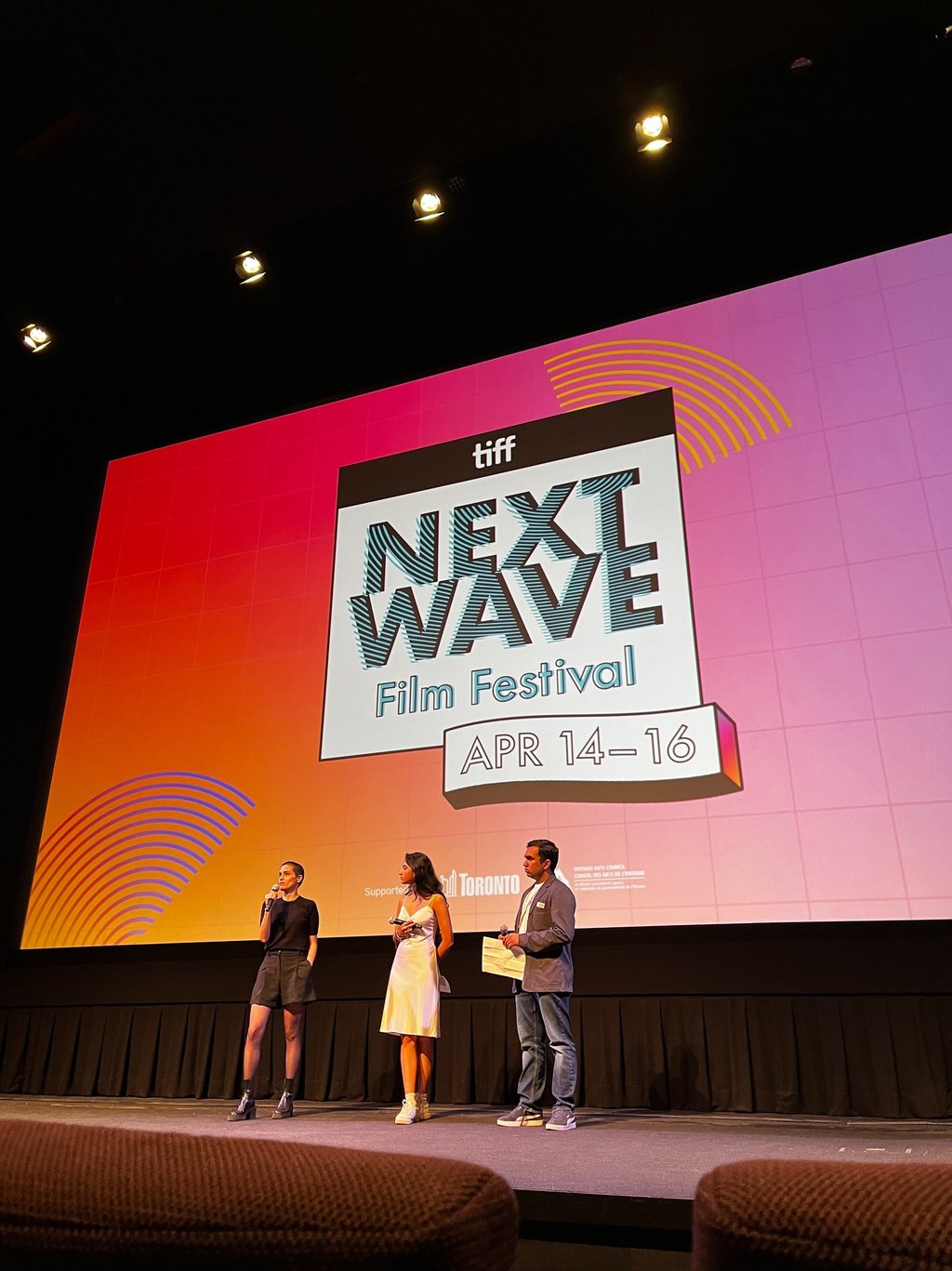 three people standing on a stage 