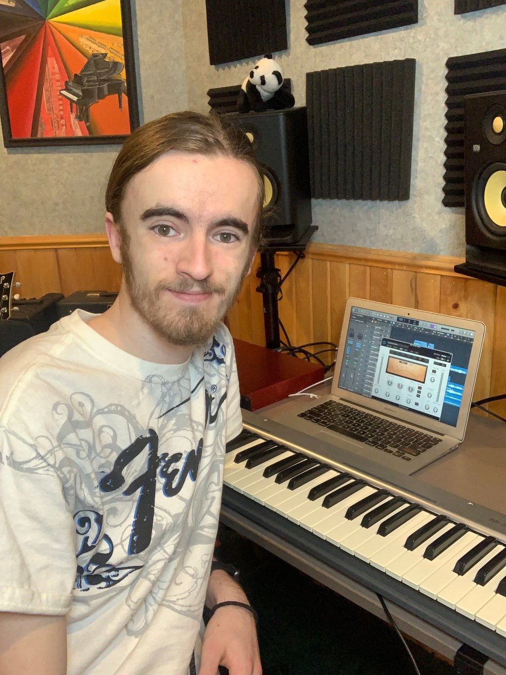 Camus Smiling at the camera while sitting at the desk at music man studios