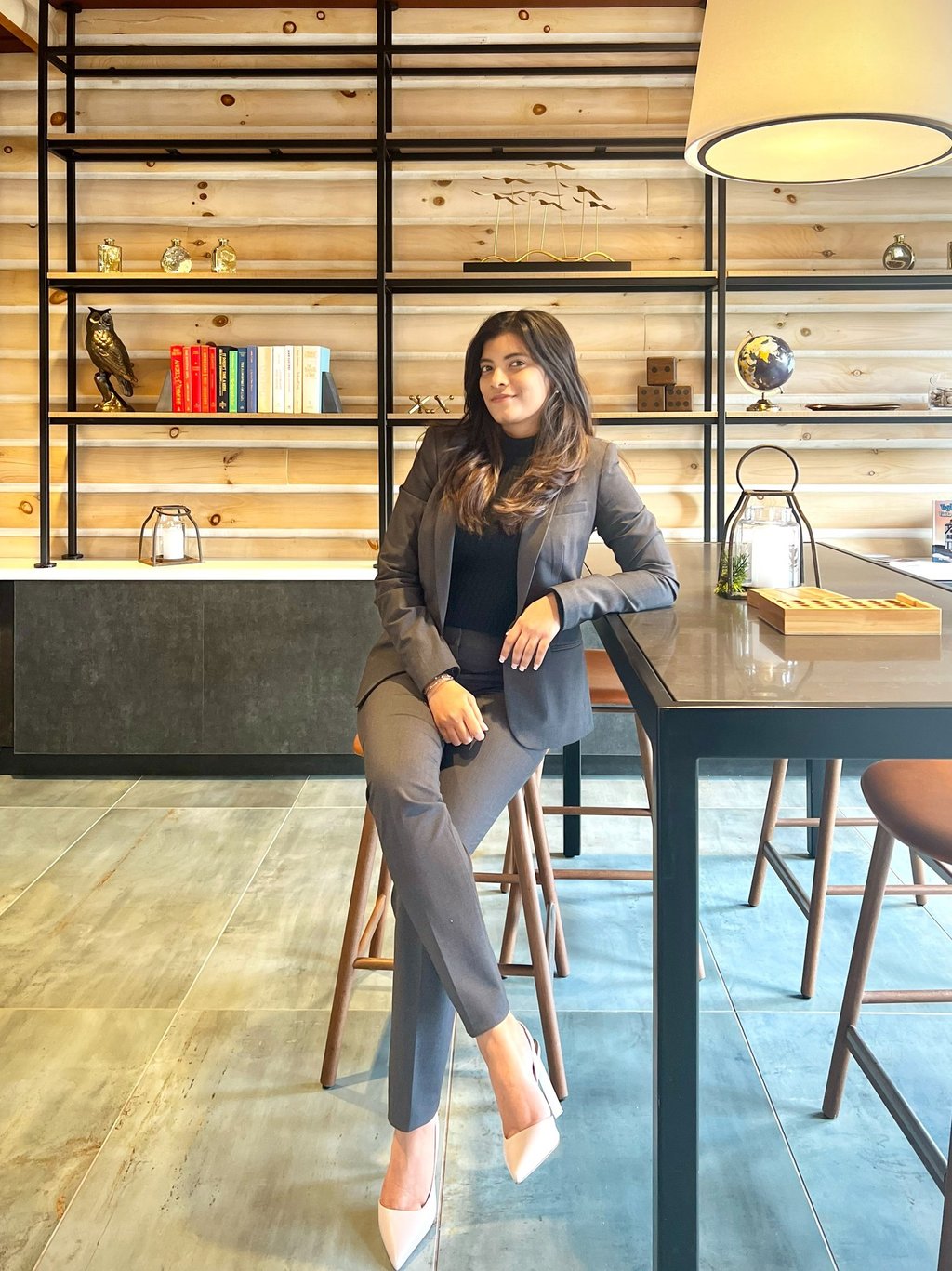 a woman sitting at a table with a lamp on it