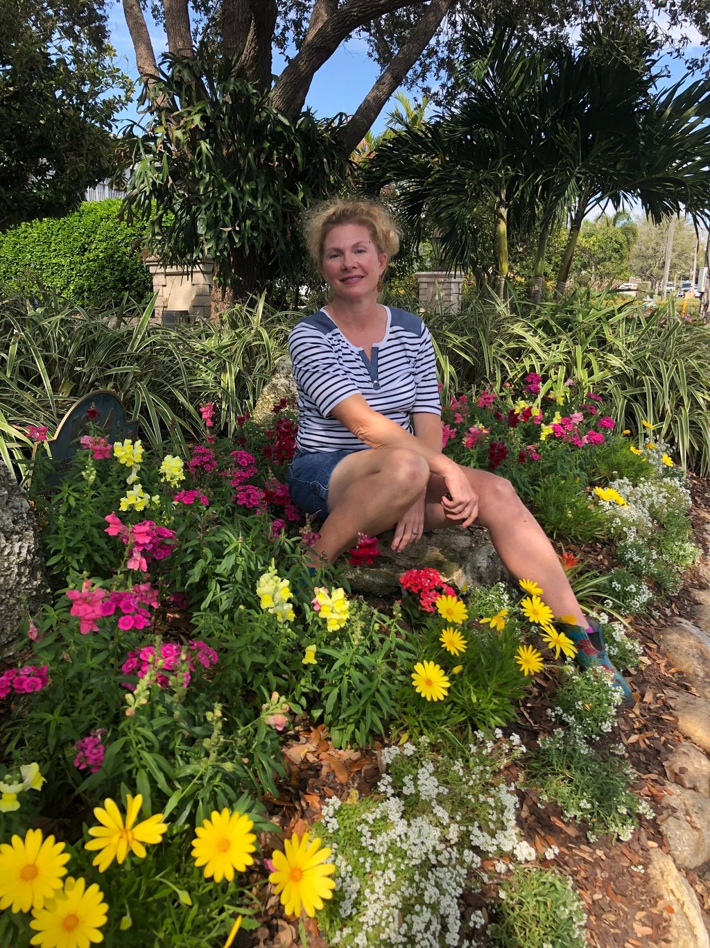 Melanie the owner sitting on a bench in a garden