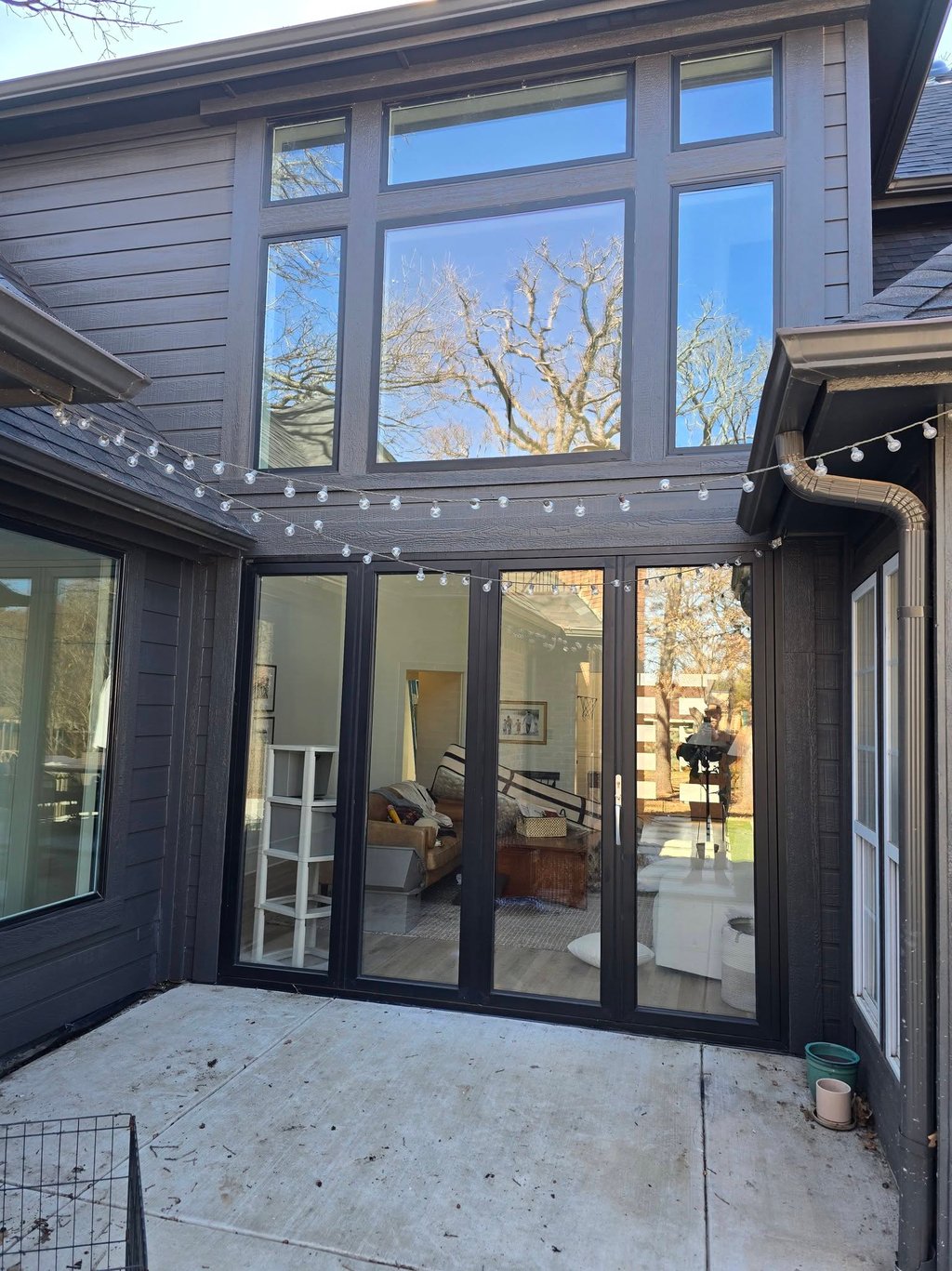 Modern dark grey home exterior featuring large black frame windows, freshly sealed and painted