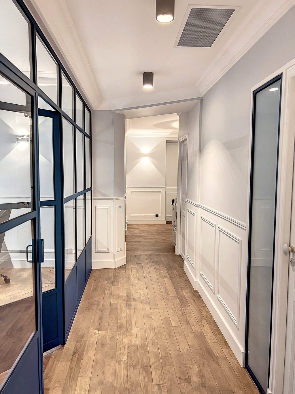 a hallway with a wooden floor and a door