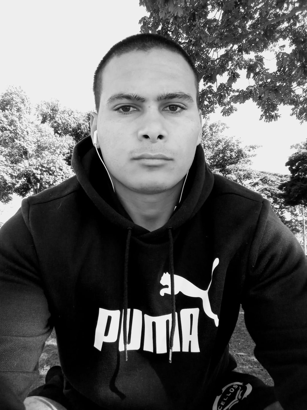 Homem com blusa, fone de ouvido e olhar sério