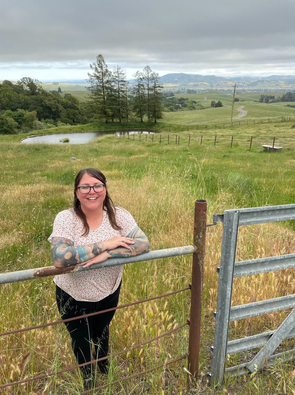 a woman standing in front of a fenced in area