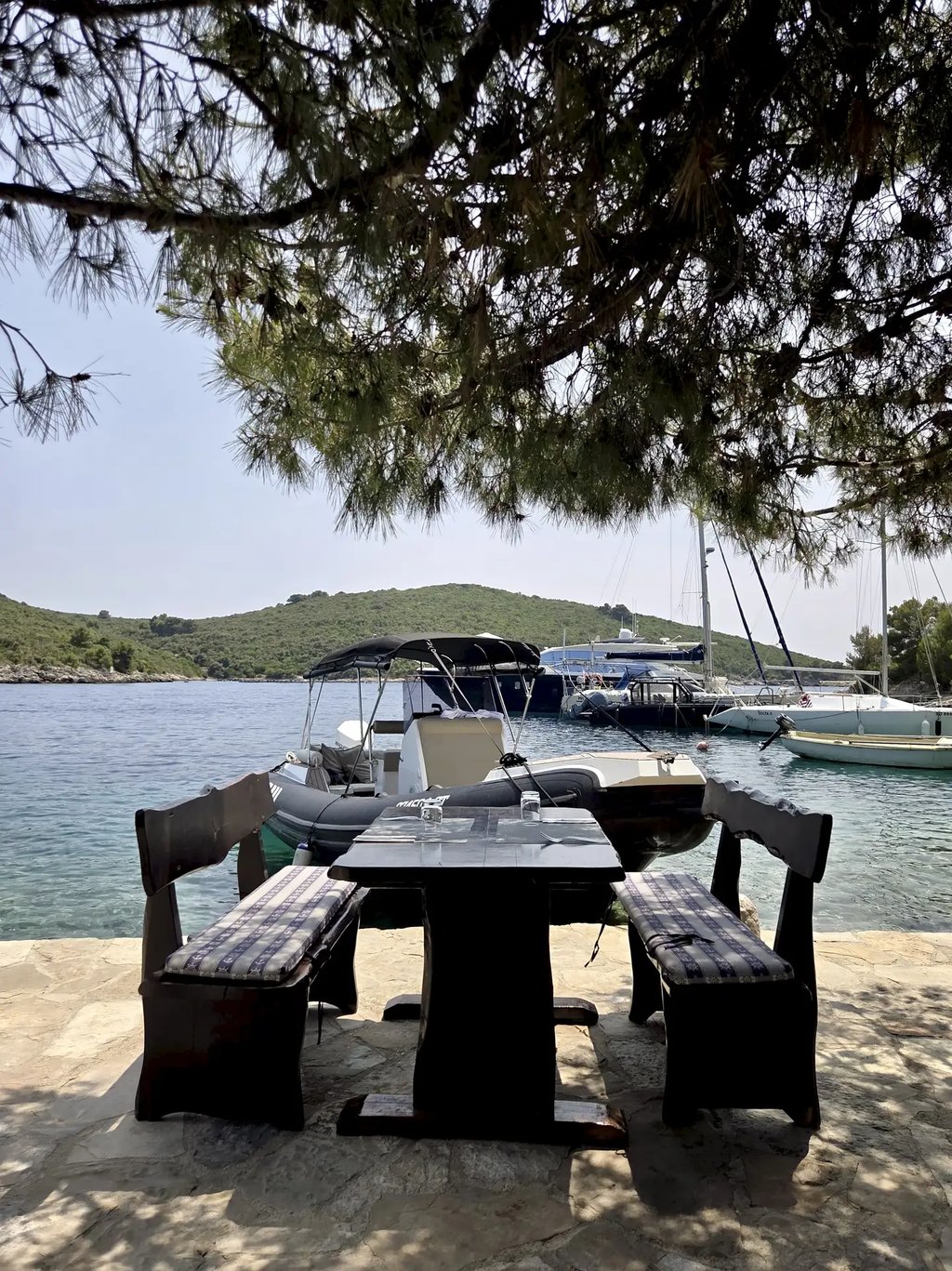 Outdoor dining table at Restaurant Sesula on Solta and speedboat in the background during a private boat tour from Split