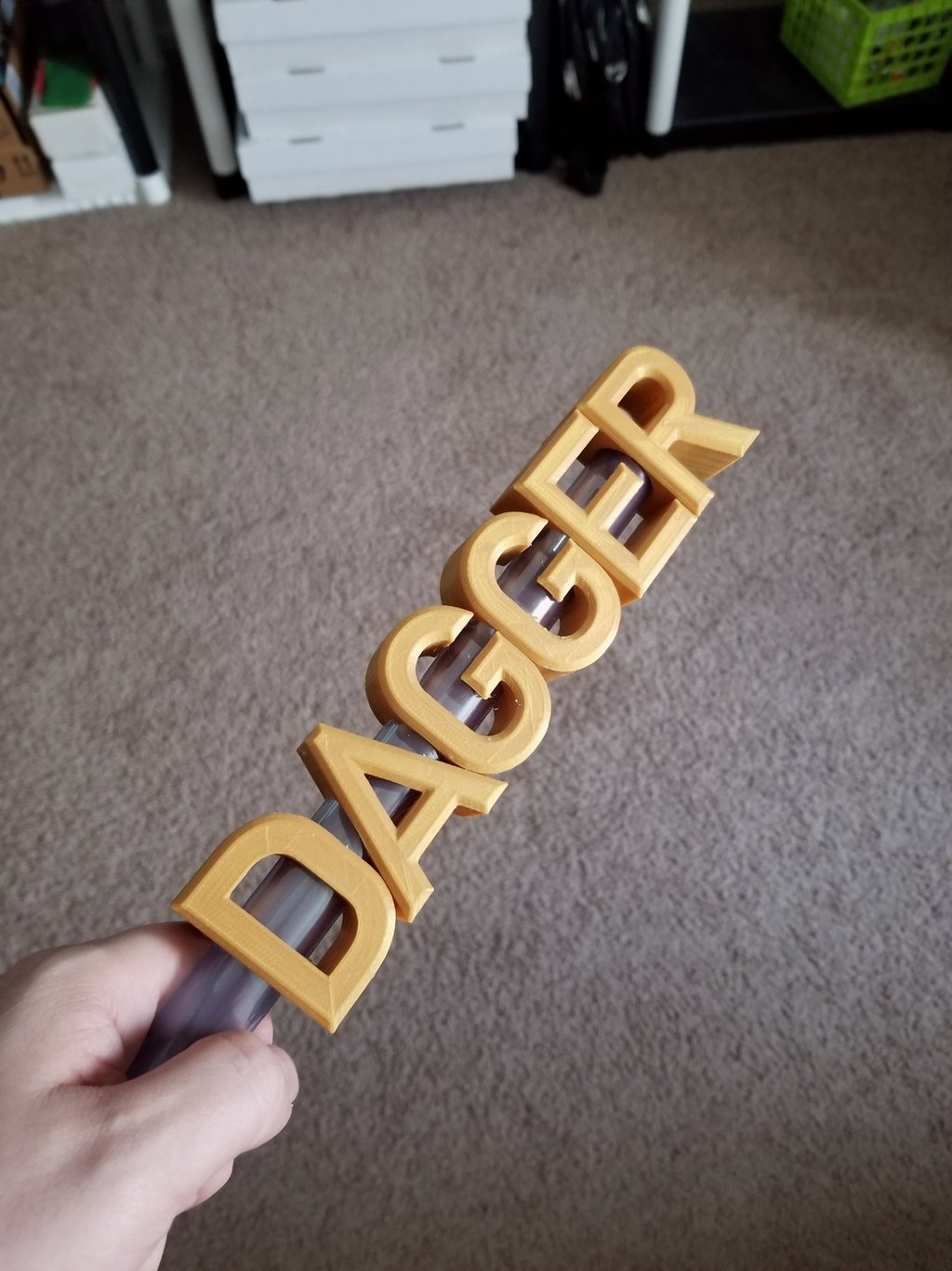 A 3d printed dagger with the blade forming the word dagger